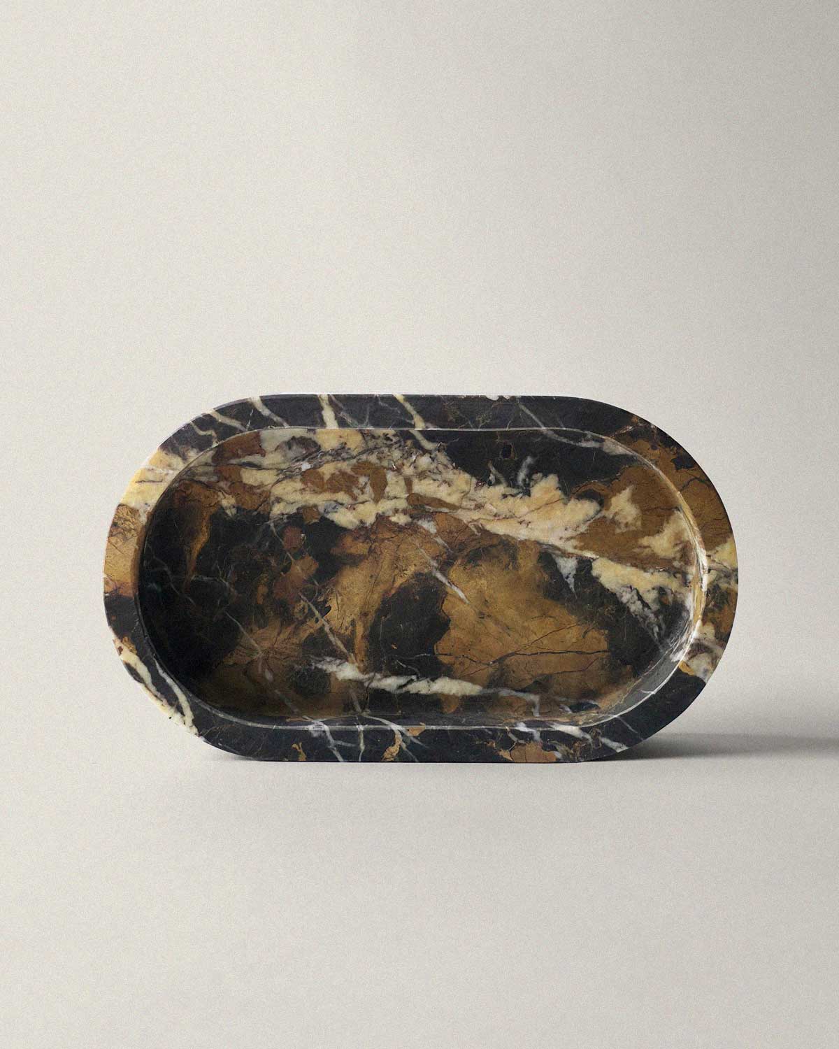 Black marble oval bathroom tray on a beige background