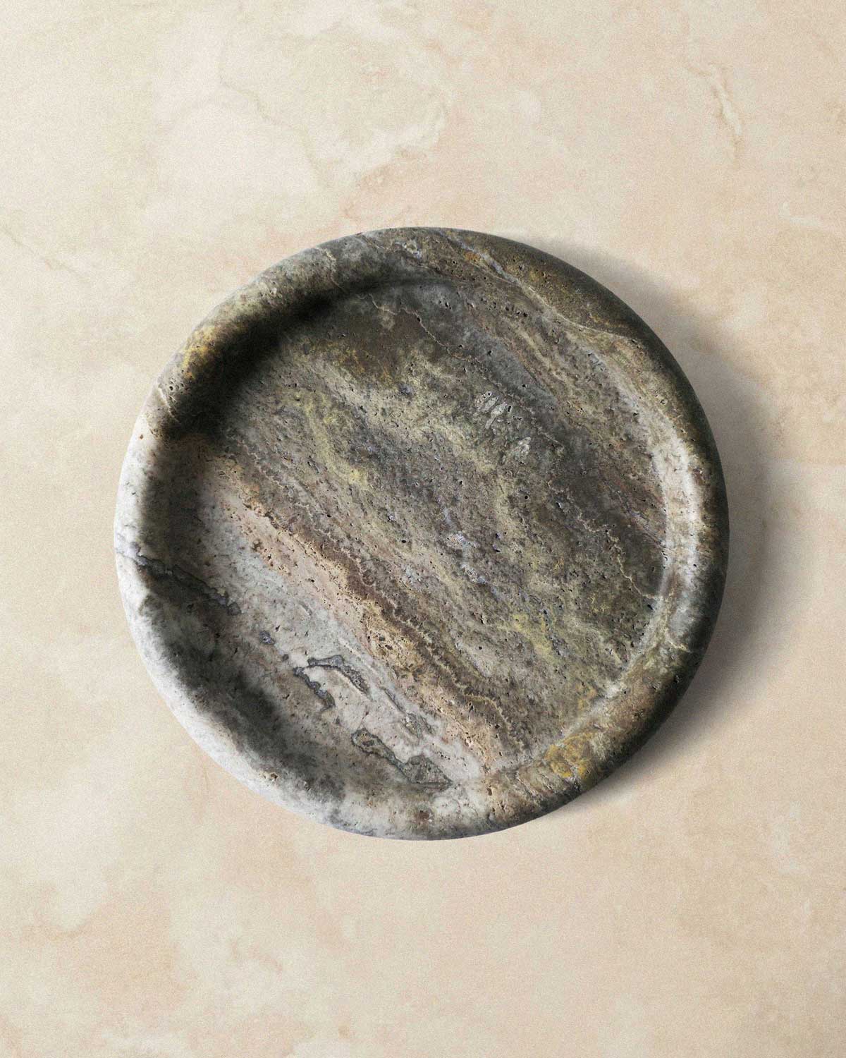 Round grey marble catchall tray on a beige surface