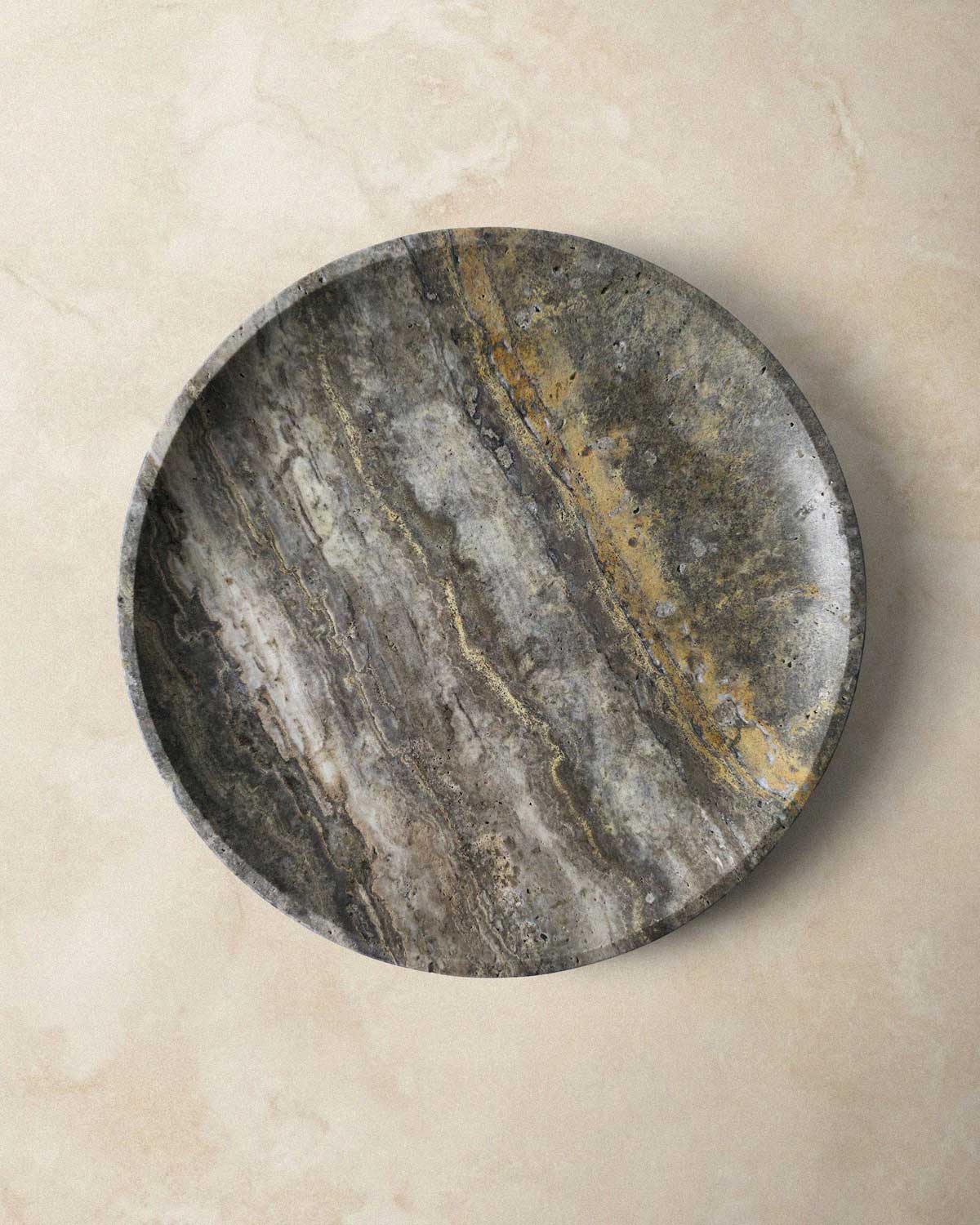 Round grey marble tray on a beige surface