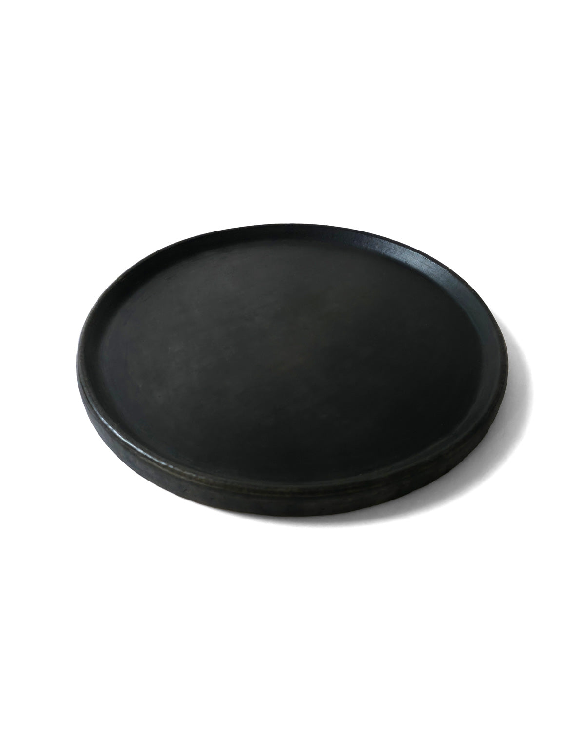 Side-angle of Oaxacan black clay dinner plate.