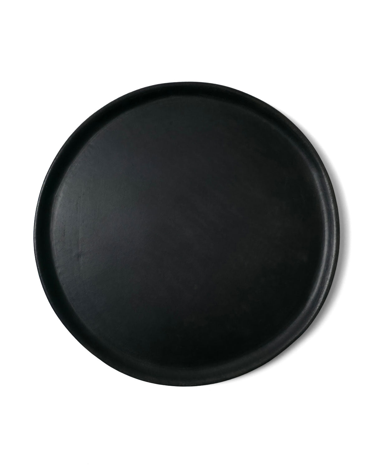 Top view of matte Oaxacan black clay serving platter on white backdrop.