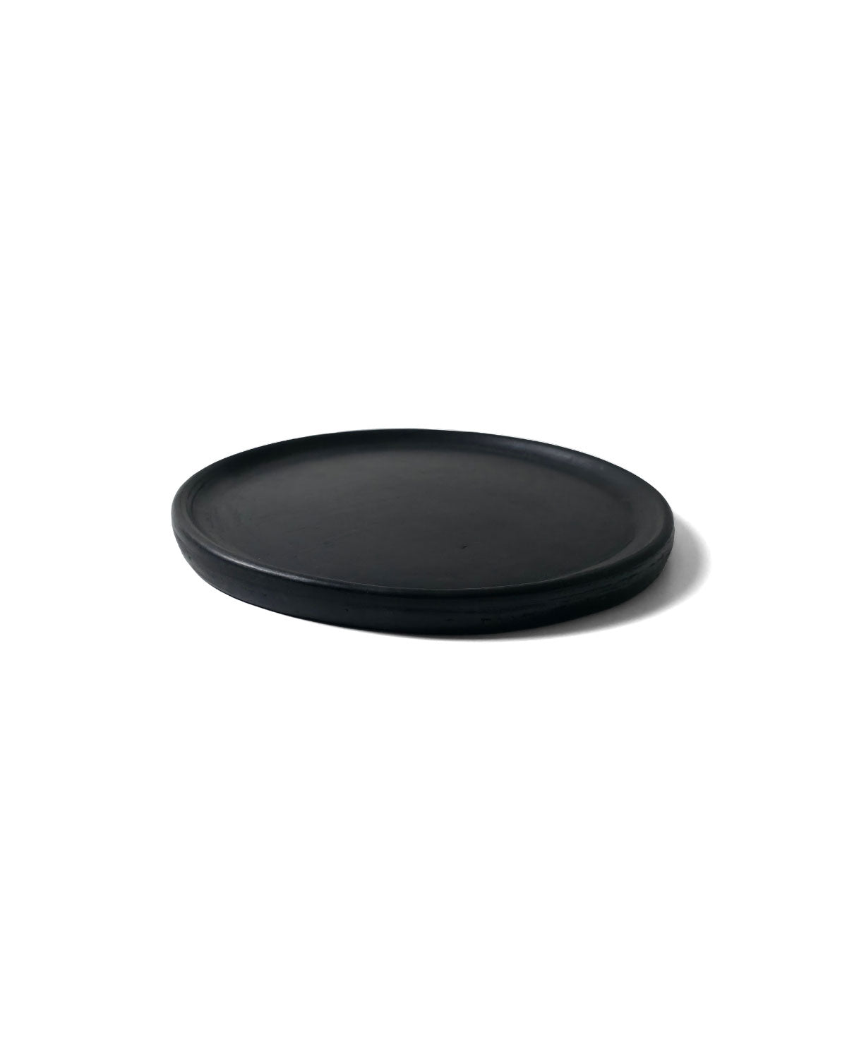 Side profile of Oaxacan black salad plate showing raised rim and matte finish.