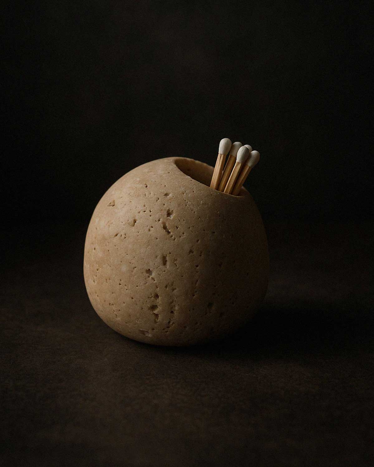 Roca Match Holder filled with matchsticks, crafted from beige travertine stone