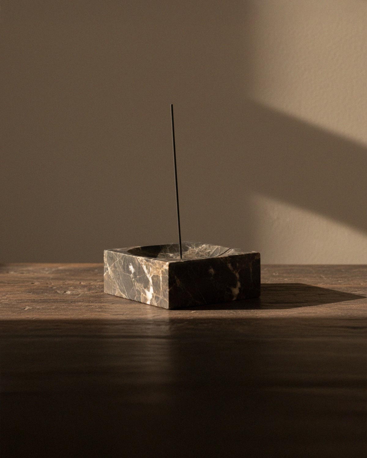 Marble incense holder with incense stick in place.