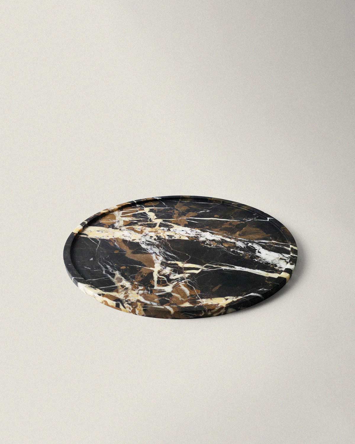 Round black marble decorative tray on a light background