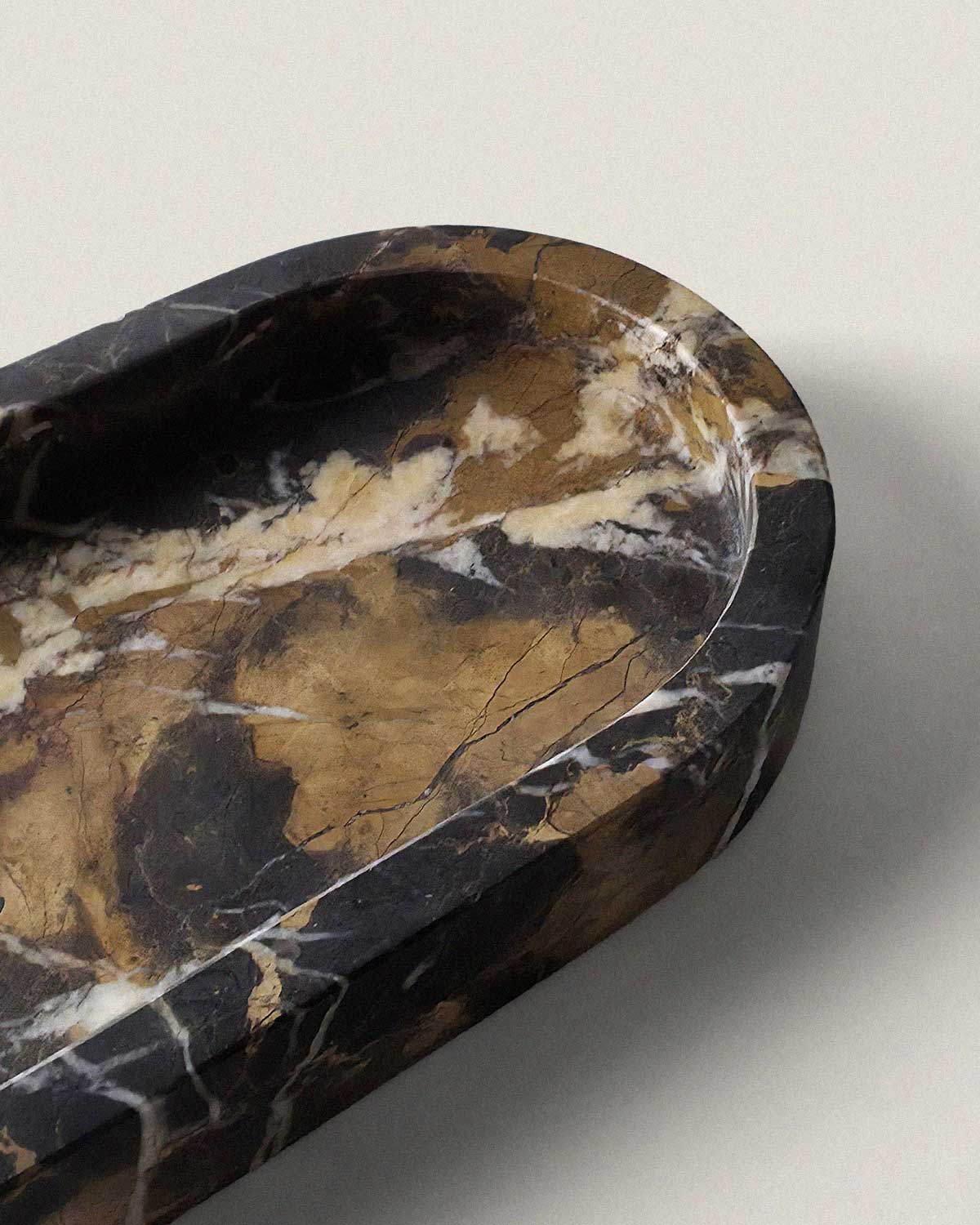 Black marble oval bathroom tray on a beige background
