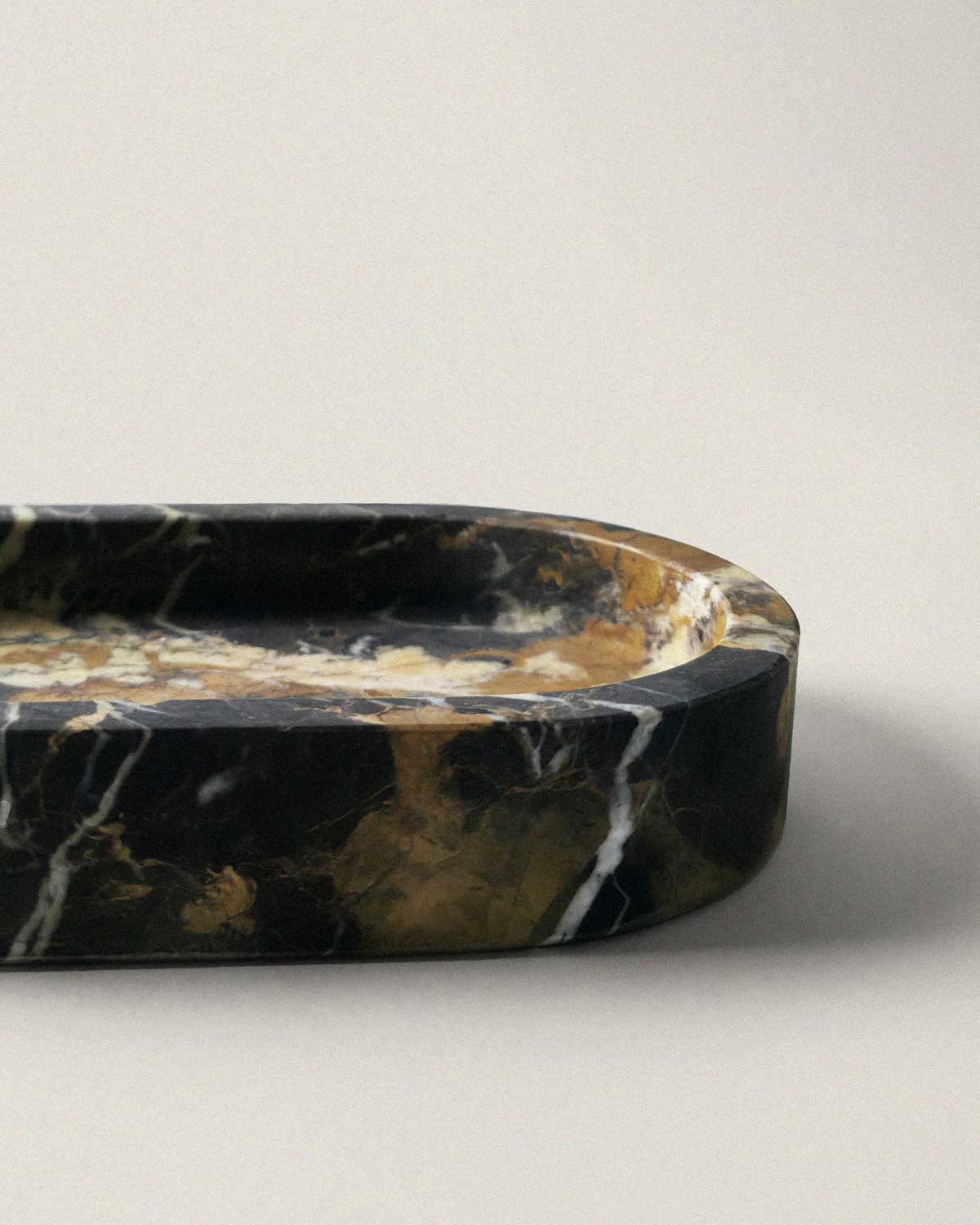 Black marble oval bathroom tray on a beige background