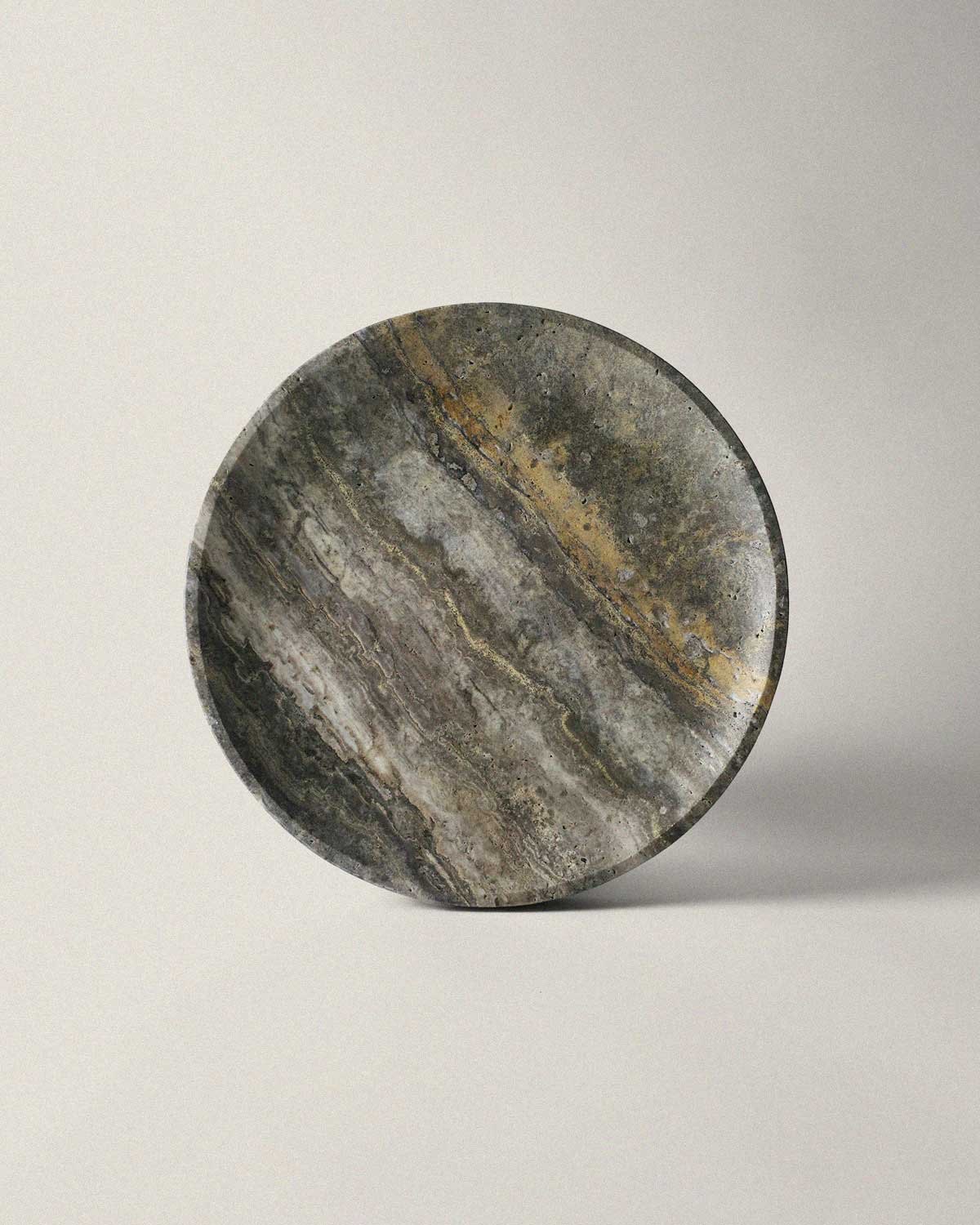 Round grey marble tray on a light gray background