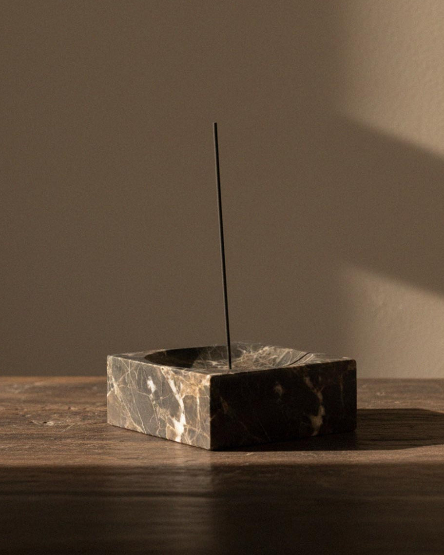 Marble incense holder with incense stick in place.